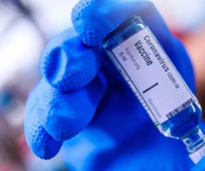 Image of Hand holds Coronavirus Covid-19 Vaccine glass bottle.