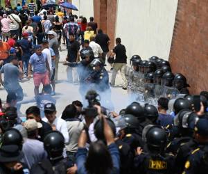 <i>Los agentes de policía disparan gases lacrimógenos para dispersar a los votantes que protestan frente a un colegio electoral que permanece cerrado tras presuntas amenazas e irregularidades durante las elecciones generales, en San José del Golfo, en las afueras del norte de la ciudad de Guatemala, el 25 de junio de 2023. (Foto de Johan ORDONEZ / AFP)</i>