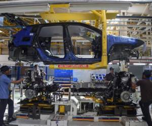 In this photograph taken on July 23, 2019 workers assemble a car at a FCA India Automobiles manufacturing facility in Ranjangaon, some 200km east of Mumbai. (Photo by Indranil MUKHERJEE / AFP)