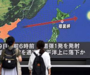 Pedestrians watch the news on a huge screen displaying a map of Japan (R) and the Korean Peninsula, in Tokyo on August 29, 2017, following a North Korean missile test that passed over Japan.Japanese Prime Minister Shinzo Abe said on August 29 that he and US President Donald Trump agreed to hike pressure on North Korea after it launched a ballistic missile over Japan, in Pyongyang's most serious provocation in years. / AFP PHOTO / Toshifumi KITAMURA