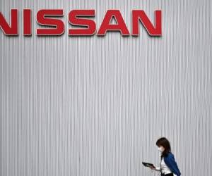 A woman walks around the Nissan Motor Corporation headquarters in Yokohama on May 28, 2020. (Photo by CHARLY TRIBALLEAU / AFP)