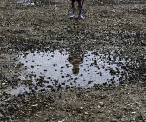 A child searches for live mollusks in Conchagua, 207 km east of San Salvador, on November 19, 2019. - The death of an uncountable number of mollusks, mostly clams and mussels, has alarmed local artisanal fishermen in the Bay of La Union, on the Pacific coast of El Salvador. The remains of the mollusks are visible along about 7 kilometers when the tide falls at the bay's beach. (Photo by MARVIN RECINOS / AFP)