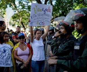 Activists opposing Venezuelan President Nicolas Maduro demand the release of the body of rogue pilot Oscar Perez, who was killed during a bloody police assault to arrest him, outside the morgue in Caracas on January 20, 2018.Perez, Venezuela's most wanted man since June when he flew a stolen police helicopter over Caracas dropping grenades on the Supreme Court and opening fire on the Interior Ministry, had gone on social media while the operation was under way on January 16 to say he and his group wanted to surrender but were under unrelenting sniper fire. That has raised questions about the government's account that the seven dissidents killed had opened fire on police who had gone to arrest them. / AFP PHOTO / Federico PARRA