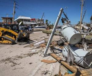 Trabajadores del Departamento de Transporte de Florida limpian escombros en Fort Myers Beach después del huracán Ian el 30 de septiembre de 2022. - Los meteorólogos esperan que el huracán Ian cause marejadas ciclónicas potencialmente mortales en las Carolinas el viernes después de desatar la devastación en Florida, donde dejó un número aún desconocido de muertos a su paso. Después de debilitarse en Florida, Ian recuperó su estatus de Categoría 1 en el Océano Atlántico y se dirigía hacia las Carolinas, dijo el viernes el Centro Nacional de Huracanes de EE. UU. (Foto de Giorgio VIERA / AFP)