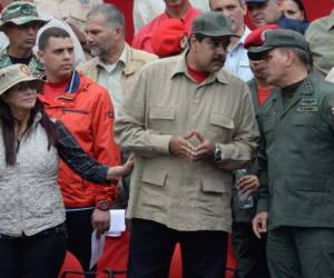 El presidente venezolano Nicolás Maduro habla con el Ministro de Defensa Padrino Lopez. Les acompaña la esposa de Maduro, Cilia Flores.