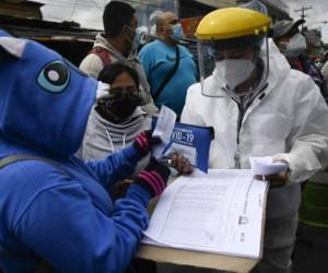 A health worker delivers medicines to patients who tested positive for a Covid-19 test at a mobile laboratory, during a spike in the number of positive coronavirus cases, in Guatemala City, August 25, 2021. - (Photo by Johan ORDONEZ / AFP)