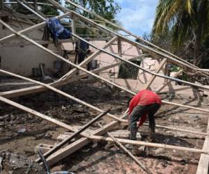 Trabajadores reparan una casa destruida durante los huracanes Eta e Iota en 2020 en el caserío El Buen Samaritano, municipio de La Lima, Departamento de Cortés, Honduras, el 8 de enero de 2021. La toma de posesión del futuro presidente estadounidense Joe Biden el 20 de enero de 2021, la novela La pandemia de coronavirus y los huracanes Eta e Iota -que en noviembre de 2020 dejaron bajo el agua gran parte del corazón industrial del país en el norte del Valle de Sula después de que lluvias torrenciales provocaron el desbordamiento de los caudalosos ríos Ulua y Chamelecon- están estimulando la migración desde Centroamérica hacia Estados Unidos.