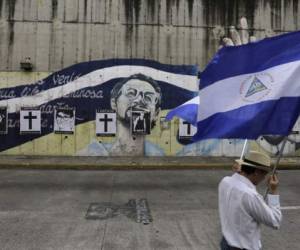A Nicaraguan opposition demonstrator holds a national flag, as he takes part in a nationwide march called 'United we are a volcano' in Managua on July 12, 2018.Opposition activists are steeling themselves for three days of protests against Nicaragua President Daniel Ortega, as fears mount over the brutal suppresion of dissent by government forces. Demonstrators marched through the capital Managua on Thursday before a general strike on Friday and a tour of Managua's most restive neighborhoods on Saturday. / AFP PHOTO / INTI OCON
