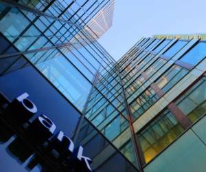 Bank corporate finance building seen from below. The sign 'bank' visible close. Sky reflecting in the glass facade. More Facade pictures below