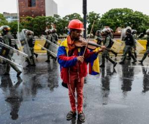 El activista opositor Wuilly Arteaga es uno de los símbolos de la protesta contra Nicolás Maduro por su peculiar forma de mostrar su descontento: tocanco el violín. Artega, de 23 años, fue arrestado el 27 de julio en la huelga de 48 horas. Foto AFP.