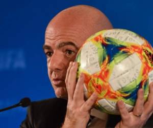 (FILES) In this file photo taken on October 24, 2019 FIFA President Gianni Infantino holds a ball while speaking at a press conference during the football federation's Council meeting in Shanghai on October 24, 2019. - A special prosecutor looking into dealings between Swiss Attorney General Michael Lauber and FIFA President Gianni Infantino has launched criminal proceedings against the FIFA president. (Photo by HECTOR RETAMAL / AFP)