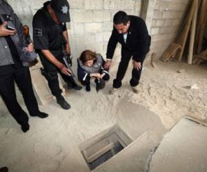 Autoridades judiciales de México observan el túnel que sirvió de escape al capo narco Guzmán. (Foto: AFP)