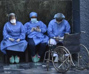 Health workers wear face masks and face shields against the spread of the new coronavirus at the Honduran Institute of Security in Tegucigalpa, where a patient died on March 31, 2020. - 141 cases of COVID-19 were registered so far in the Central American nation. (Photo by ORLANDO SIERRA / AFP)