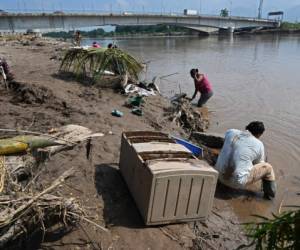 People affected by the passage of Hurricane Eta wash clothes in the Ulua River in El Progreso, Yoro department, Honduras, On November 15 2020, before the arrival of Hurricane Iota. - Hurricane Iota is forecast to strengthen to an 'extremely dangerous' Category Four by the time it makes landfall in Central America on Monday, the US National Hurricane Center warned, two weeks after powerful storm Eta devastated much of the region and left more than 200 people dead or missing. (Photo by Orlando SIERRA / AFP)