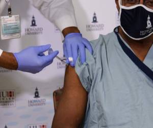 Dr. Hugh Mighty, Dean of the College of Medicine at Howard University, receives a Covid-19 vaccine at Howard University Hospital in Washington, DC, on December 15, 2020. (Photo by NICHOLAS KAMM / AFP)