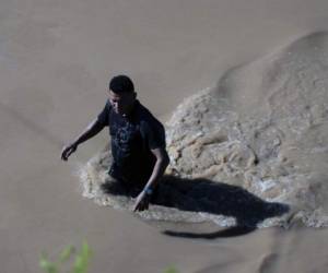 A man wades on the road that connects the city of El Progreso, department of Yoro, with the municipality of La Lima, department of Cortes, on November 7, 2020. - Scores of people have died or remain unaccounted for as the remnants of Hurricane Eta unleashed floods and triggered landslides on its deadly march across Central America. (Photo by Orlando SIERRA / AFP)