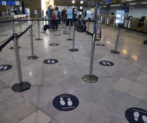 Stickers mark out social distancing spacing on the floor at the check-in queue for Air France in Terminal 2 of Charles de Gaulle international airport in Roissy near Paris, on May 14, 2020, as France eases lockdown measures taken to curb the spread of the COVID-19 (the novel coronavirus). (Photo by Ian LANGSDON / EPA POOL / AFP)