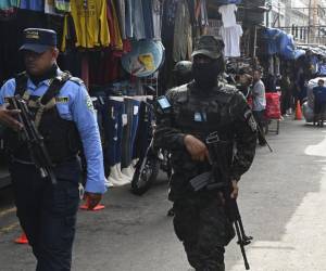 <i>Un miembro del Ejército de Honduras y la Policía Nacional patrullan una calle durante un operativo de seguridad llamado Mercados Seguros en Tegucigalpa el 14 de julio de 2023. Los índices de violencia y delincuencia están bajando en Honduras, luego de que la presidenta Xiomara Castro ordenara el desarme de las pandillas Barrio-18 y Mara Salvatrucha (MS-13) en las 21 cárceles del país y la implementación de toques de queda en los municipios de Choloma y San Pedro Sula, en el norte Honduras. Foto Orlando Sierra / AFP</i>