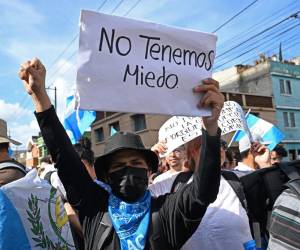 <i>La gente participa en una manifestación frente a la sede de la Fiscalía General de la República en Ciudad de Guatemala el 13 de julio de 2023. El tribunal supremo de Guatemala suspendió el jueves una orden judicial que inhabilitó al partido Semilla, del candidato socialdemócrata Bernardo Arévalo, que en la práctica impedía impidiéndole disputar la boleta electoral del 20 de agosto. Una resolución de la Corte Constitucional (CC) otorgó una protección provisional a Arévalo, revirtiendo así el fallo del juez Fredy Orellana que puso en jaque la participación de Semilla, informó la entidad en un comunicado. (Foto por Johan ORDONEZ / AFP)</i>