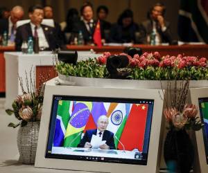 <i>Los delegados asisten a la sesión plenaria mientras el presidente ruso Vladimir Putin pronuncia su discurso virtualmente durante la Cumbre BRICS 2023 en el Centro de Convenciones Sandton en Johannesburgo el 23 de agosto de 2023. (Foto de GIANLUIGI GUERCIA / POOL / AFP)</i>