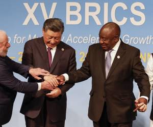 <i>(De izquierda a derecha) El presidente de Brasil, Luiz Inácio Lula da Silva, el presidente de China, Xi Jinping, y el presidente sudafricano, Cyril Ramaphosa, hacen un gesto durante la Cumbre BRICS de 2023 en el Centro de Convenciones de Sandton en Johannesburgo el 23 de agosto de 2023. (Foto de GIANLUIGI GUERCIA / PISCINA / AFP)</i>
