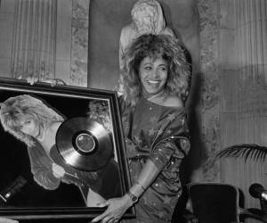 <i>La cantante estadounidense Tina Turner recibe el premio Disco de oro de manos del presidente de Pathé Marconi, Guy Deluz (izquierda), el 8 de octubre de 1986 en París. La cantante que electrizó al público desde la década de 1960 y lanzó discos exitosos durante cinco décadas, murió a la edad de 83 años (Foto de Georges BENDRIHEM / AFP)</i>