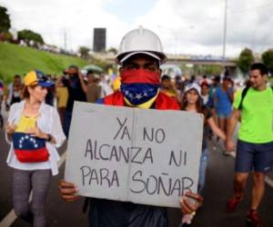 Un opositor venezolano marcha en las calles de Caracas con el cartel que dice 'Ya no alcanza ni para soñar', en el marco de las protestas contra el gobierno de Nicolás Maduro a quien acusan de instituir una dictadura, en medio de una crisis inflacionaria y una cada vez mayor falta de medicamentos y alimentos.