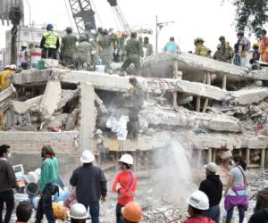 Rescuers and volunteers work clearing from rubble and debris the site where a multistory building was flattened by a 7.1-magnitude quake on the eve searching for survivors, in Mexico City, on September 20, 2019. Rescuers frantically searched Wednesday for survivors of a powerful earthquake that killed more than 200 people in Mexico on the anniversary of another massive quake that left thousands dead and still haunts the country. / AFP PHOTO / YURI CORTEZ