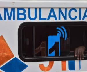 The hand of man infected with COVID-19 is seen out of the window of an ambulance as he arrives at a field hospital set up in the yard of a state hospital in Tegucigalpa, on June 11, 2020. - The authorities of the main hospital of the Honduran capital were forced to set up four tents to assist coronavirus patients since its rooms were overcrowded. (Photo by ORLANDO SIERRA / AFP)