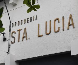 <i>Vista de la droguería Santa Lucía, propiedad del expresidente salvadoreño Alfredo Cristiani, acusado de corrupción, mientras policías la custodian luego de que el presidente Nayib Bukele anunciara un operativo para allanar las propiedades de Cristiani en San Salvador el 2 de junio de 2023. FOTO MARVIN RECINOS / AFP</i>