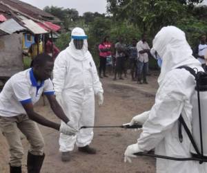 Health workers wash their hands after taking a blood specimen from a child to test for the Ebola virus in an area where a 17-year old boy died from the virus on the outskirts of Monrovia, Liberia, Tuesday, June 30, 2015. Liberian authorities on Tuesday quarantined the area where the corpse of the boy was found, sparking fears this West African country could face another outbreak of the disease nearly two months after being declared Ebola-free. (AP Photo/ Abbas Dulleh)