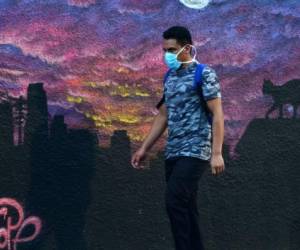 A woman wears a face mask during the COVID-19 pandemic, at a street market in Tegucigalpa on June 8, 2020, after the governmet announced the resumption of economic activity. - Honduras reopens its business activities, cautiously, after almost three months of confinement, though, according to experts, at the worst time to do so due to the rapid rise of the coronavirus and at high risk of closing again. (Photo by ORLANDO SIERRA / AFP)