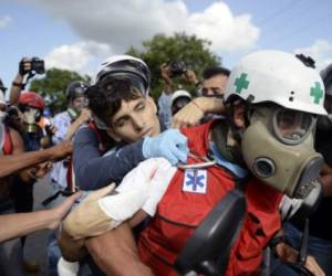 A seemingly unconscious demonstrator hit by a rubber bullet shot by riot police is carried away by volunteer medics as opposition activists and riot police clash during an anti-government protest in Caracas, on June 22, 2017. / AFP PHOTO / FEDERICO PARRA