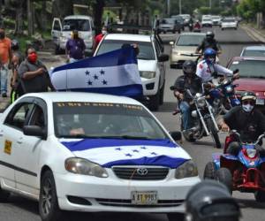 Taxi drivers with Honduran flags block a road to protest in demand of food and economic aid in Tegucigalpa, on May 28, 2020, amid the new coronavirus pandemic. - Taxi drivers protested for the second consecutive day Thursday arguing they are facing a difficult economic situation due to the population's confinement. Honduras has registered 194 deceased out of a total of 4,640 confirmed cases of COVID-19 so far. (Photo by ORLANDO SIERRA / AFP)