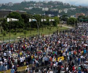 Opposition activists demonstrate against the government of Venezuelan President Nicolas Maduro in Caracas on June 24, 2017, in front of the Francisco de Miranda air force base near the place where a young man was shot dead by police during an anti-government rally two days ago. A political and economic crisis in the oil-producing country has spawned often violent demonstrations by protesters demanding Maduro's resignation and new elections. The unrest has left 75 people dead since April 1. / AFP PHOTO / FEDERICO PARRA