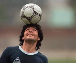 (FILES) In this file picture taken on May 22, 1986 Argentine football star Diego Maradona, wearing a diamond earring, balances a soccer ball on his head as he walks off the practice field following the national team's practice session in Mexico City. - Argentine football legend Diego Maradona turns 60 on October 30, 2020. (Photo by JORGE DURAN / AFP)