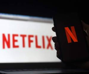 In this photo illustration a computer and a mobile phone screen display the Netflix logo on March 31, 2020 in Arlington, Virginia. - According to Netflix chief content officer Ted Sarandos, Netflix viewership is on the rise during the coronavirus outbreak. (Photo by Olivier DOULIERY / AFP)