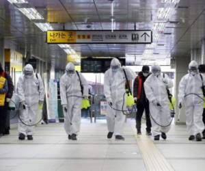 Trabajadores en Corea del Sur desinfectan la estación del metro de Seúl el 11 de marzo de 2020. Corea del sur ha confirmado 7.513 casos y es el segundo país con más contagiados detrás de China, cuna del virus, aunque el número de nuevos casos ha declinado en los últimos días. FOTO AFP