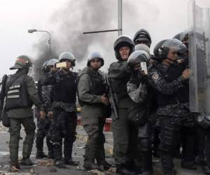 Miembros de las fuerzas de seguridad venezolanas resisten los ataques de los manifestantes el fin de semana del 23 y 24 de febrero. Foto: AFP.