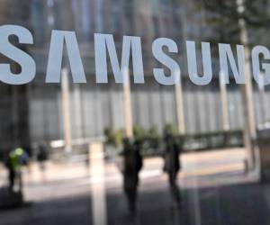 <i>(ARCHIVOS) La gente pasa junto al logotipo de Samsung exhibido en una puerta de vidrio en el edificio Seocho de la compañía en Seúl el 5 de abril de 2024. El 15 de abril de 2024, Estados Unidos anunció subvenciones de hasta 6.400 millones de dólares al gigante surcoreano de semiconductores Samsung para producir chips de última generación en Texas. FOTO Jung Yeon-je / AFP</i>