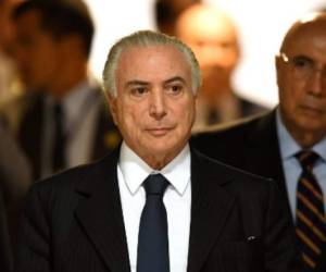 Brazilian President Michel Temer (C) arrives to the signing ceremony of a decree that fees differential prices for payment in cash and with credit card at the Planalto Palace in Brasilia, on June 26, 2017. Temer faces his own crisis with the prosecutor general expected to request formal corruption charges against the president Monday or Tuesday. / AFP PHOTO / EVARISTO SA