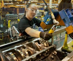 General Motors Romulus Engine Plant employee Christy Seay stuffs a piston into an 8-cylinder engine Monday, October 31, 2011 in Romulus, Michigan. General Motors announced today it will invest $385 million to prepare the facility for production of an all-new, fuel efficient engine program, creating or retaining about 320 jobs. (Photo by John F. Martin for General Motors)