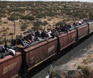 <i>Migrantes, en su mayoría de Venezuela, viajan en vagones de un tren de mercancías a Ciudad Juárez, estado de Chihuahua, México, el 3 de octubre de 2023. FOTO HERIKA MARTÍNEZ / AFP</i>