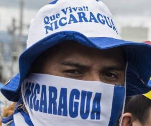 A Nicaraguan living in Costa Rica takes part in a protest outside the Nicaraguan Embassy in San Jose against Nicaraguan President Daniel Ortega, on February 27, 2019. - Ortega and the opposition opened talks Wednesday on easing tensions that began last April with deadly protests over the government's now-ditched pension reform. The opposition Civic Alliance coalition had called for the release of all opposition prisoners ahead of the talks. (Photo by Ezequiel BECERRA / AFP)