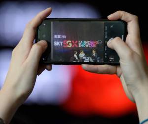 <i>Un miembro de la audiencia toma una fotografía durante un evento de lanzamiento de SK Telecom para la red móvil 5G de la compañía, en Seúl, el 3 de abril de 2019.FOTO Ed JONES/AFP</i>