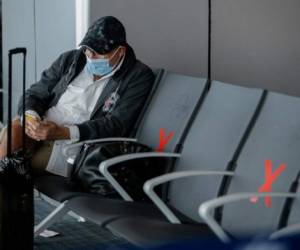 A passenger wearing a face mask waits at Tocumen International Airport in Panama City on October 12, 2020, as Panama resumed its international flight operations seven months after suspending flights due to the COVID-19 novel coronavirus pandemic. (Photo by STR / AFP)