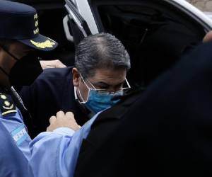 <i>Escolta policial al expresidente Juan Orlando Hernández a su llegada al Palacio de Justicia para asistir a su primera audiencia de extradición en Tegucigalpa, el 16 de febrero de 2022. FOTO ARCHIVO / AFP</i>