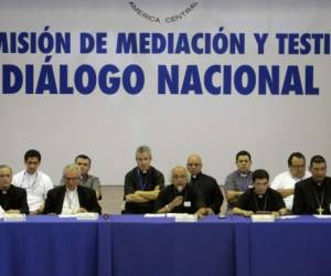 Cardinal Leopoldo Brenes (C) chairs the 4th meeting of the 'national dialogue' talks between government representatives, Nicaragua's Roman Catholic bishops and the opposition, in a bid to quell a month of anti-government unrest that has seen more than 50 people killed, at the National Seminary of Our Lady of Fatima, in Managua on May 23, 2018. / AFP PHOTO / INTI OCON