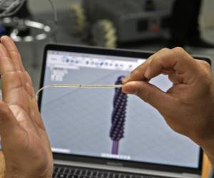 A student from the engineering school of the University of Costa Rica (UCR) tests a swab to be used for the testing of the COVID-19 coronavirus, in San Jose, on May 7, 2020. - Laboratories and investigation centers in Costa Rica have used their knowledge in order to fight the new coronavirus, coming up with a variety of products that allow the country to reduce its dependency on imported goods in moments of increasing global demand. (Photo by Ezequiel BECERRA / AFP)