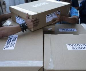 <i>Empleados del Tribunal Supremo Electoral (TSE) cargan cajas con material electoral para las elecciones presidenciales y legislativas que serán distribuidas en los diferentes municipios de la capital en la Dirección de Organización Electoral en San Marcos, El Salvador, el 2 de febrero de 2024. El Salvador va a las urnas el 4 de febrero. FOTO Yuri CORTEZ/AFP</i>